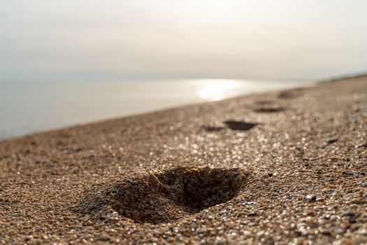 Human footprint on sand summer beach background with copyspace.