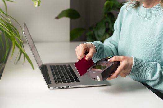 woman using payment card terminal to shop online with credit card, pos terminal