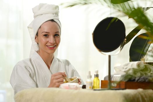 Charming caucasian lady preparing yogurt and turmeric for facial mask. Beauty treatment and self care concept.