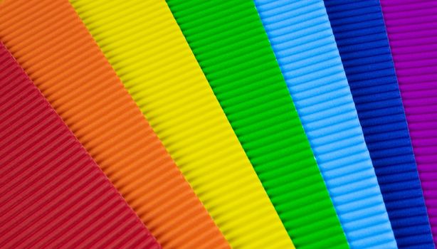 Background of colored rainbow sheets of corrugated paper.