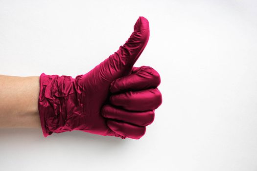 A hand in a surgical medical glove color Viva Magenta, highlighted on a white background. Production of rubber protective gloves.Hygiene and sanitary standards.