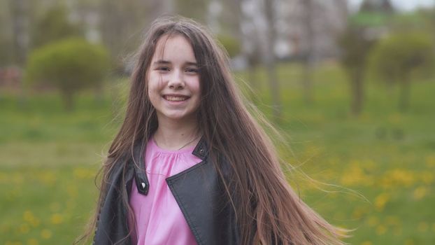 A teenage girl with long hair twirls and poses for the camera