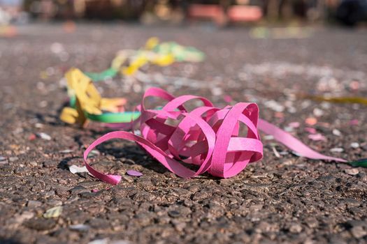 Close up colorful confetti and streamers at the street after Carnival parade