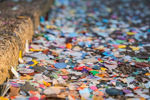 Close up colorful confetti and streamers at the street after Carnival parade