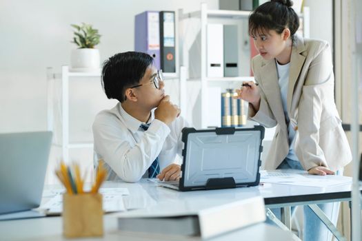 Businesspeople or colleagues are working together on investment project, discussing, sharing ideas, planning, and analyzing the business strategy and finance using laptop computer.