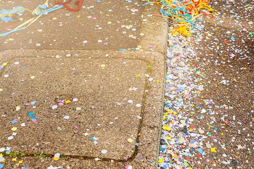 Colorful confetti and streamers at the street after Carnival parade. Italy