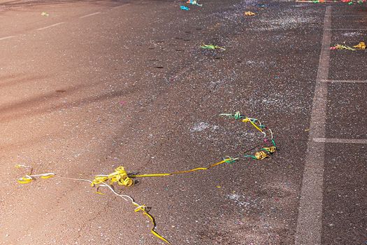 Colorful confetti and streamers at the street after Carnival parade. Italy