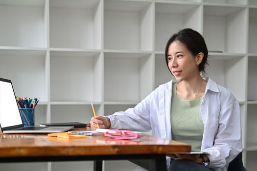 Asian woman entrepreneur working with computer laptop at modern workplace.