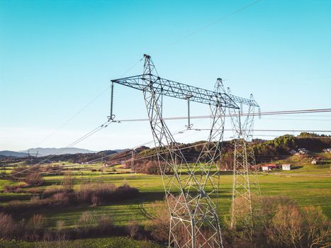 Electrical power substation in the country side of Slovenia. Fields and forests surrounding the power station in the suburbs. Aerial view.