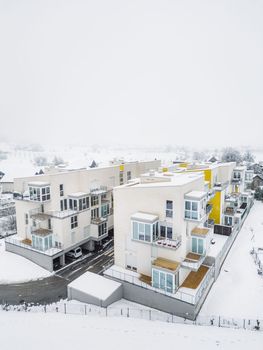 Newly build apartment complex, modern architecture, residential building on a snowy winter day.