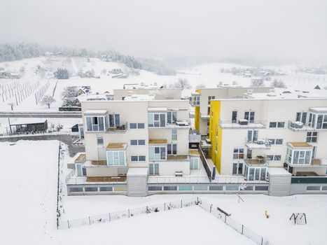 Newly build apartment complex, modern architecture, residential building on a snowy winter day.