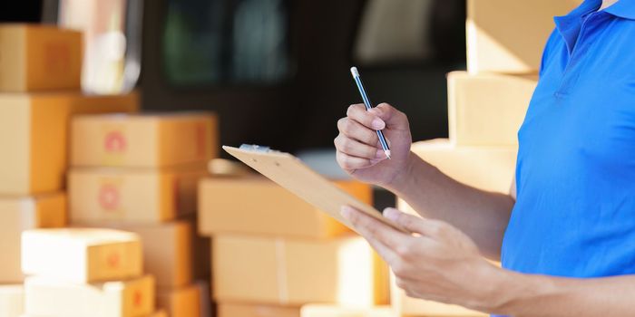 Asian courier with parcel and delivery logistic concept. Delivery man with checking list on clipboard.