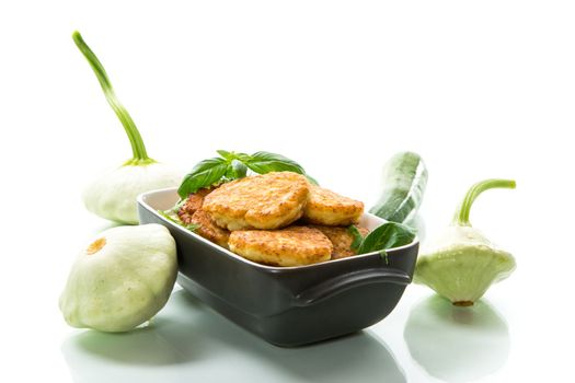 fried vegetable pancakes from squash and zucchini with greens, isolated on a white background.