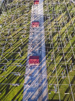 Electrical power substation in the country side of Slovenia. Fields and forests surrounding the power station in the suburbs. Aerial view.