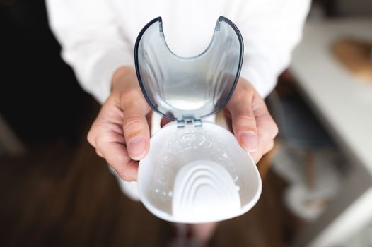 Close-up of a plastic transparent brace in a box in the hand of a young woman. selective focus.