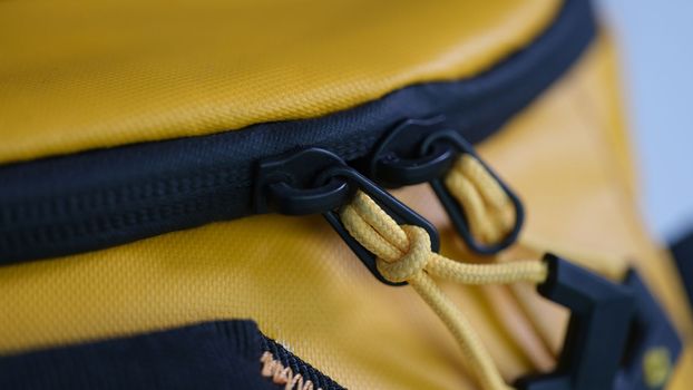 Zipper with lock on yellow backpack closeup. Men accessories concept