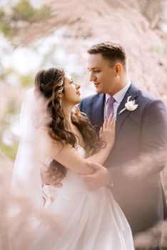 the groom and the bride are walking in the forest on a bright day