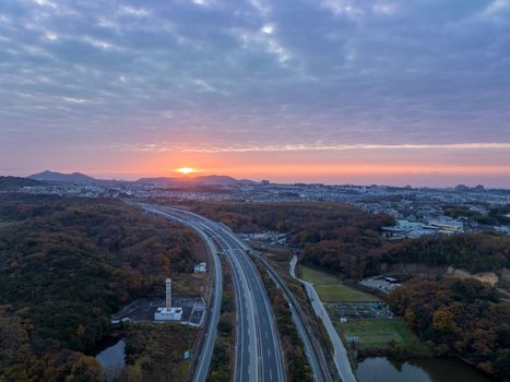 First rays of sun light sky over curved road through landscape. High quality photo