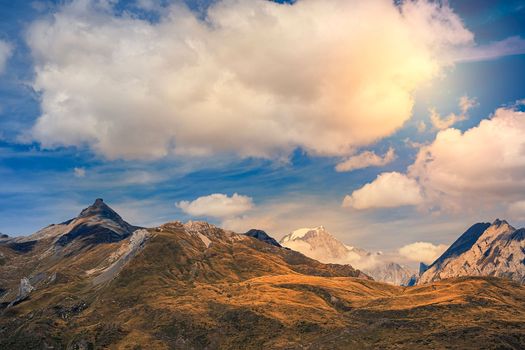 Mountain rock landscape with clouds in the blue sky. Alpine