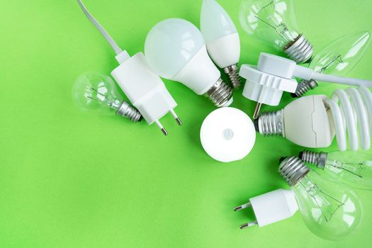 A set of different types of LED lamps isolated on a green background. Energy-saving lamps, in the center the flashlight is turned on in the center