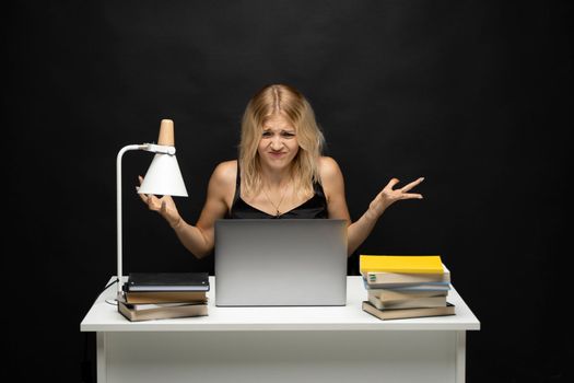 Young nervous business woman is angry on her colleague he is late with sending her an email. Frustrated businessperson in the office on laptop waiting for the contract to get by internet