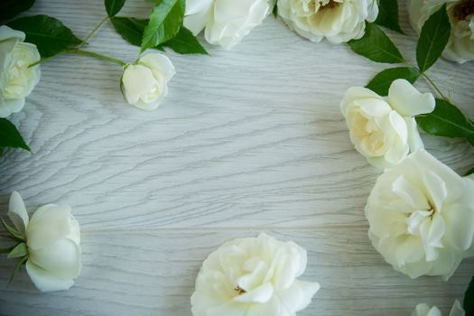 beautiful background of many white roses on a light wooden