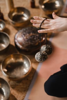 Close-up of a woman's hand holding Tibetan bells for sound therapy. Tibetan cymbals.