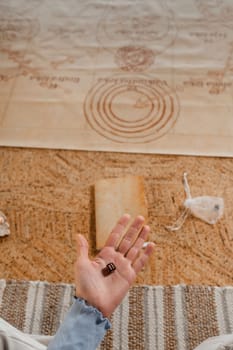 There is a dice in a person's hand. Close-up of a hand with a dice on the background of a notebook.