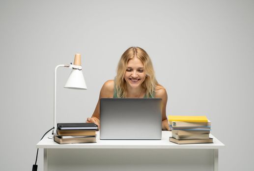 Cheerful office worker business student woman freelancer laughing in front of laptop while speaking with the partners or clients