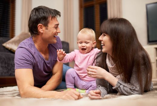 Shes such a joy. a young couple playing with their infant daughter