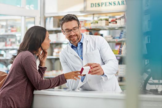 Happy, healthcare and communication of pharmacist with customer at counter for professional expertise. Advice, explanation and opinion of worker helping girl with medicine information at pharmacy