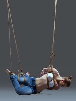 Full length portrait of young woman with shibari in studio
