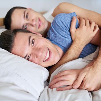 Never going to let go. Portrait of a young gay couple relaxing in bed