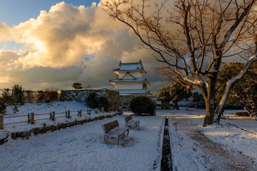 Beautiful sunrise light on historic Japanese castle on snowy winter morning. High quality photo