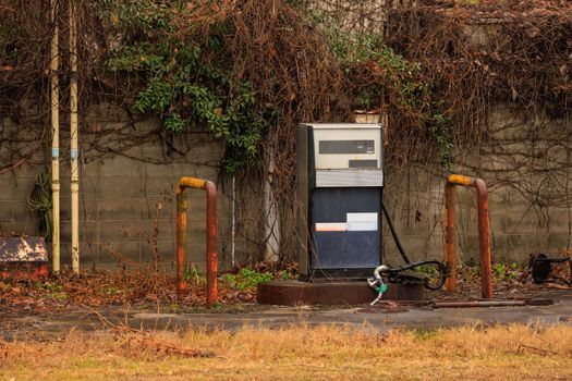 A single gas pump in an overgrown station in the Japanese countryside on rainy day. High quality photo