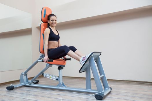 Full length portrait of athletic young woman in gym