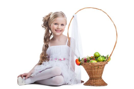 portrait of happy and young little girl with fruits. Isolated on white