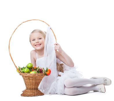 portrait of happy and young little girl with basket of fruits. Isolated on white
