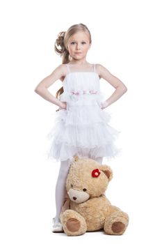 Cute little girl with teddy bear posing in studio, isolated on white