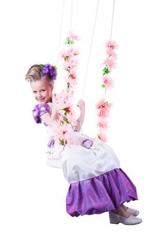 Beautiful little girl on floral swing. Isolated on white