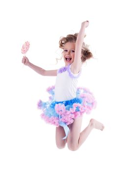 Happy little girl with lollipop jumping. Isolated on white