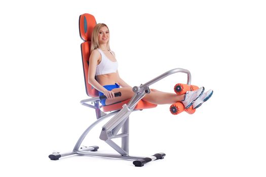 Full length portrait of blonde young woman on orange exerciser. Isolated on white