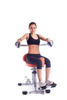 Full length portrait of brunette young woman on orange exerciser. Isolated on white