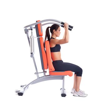 Full length portrait of athletic young brunette woman on isodynamic exerciser. Isolated on white