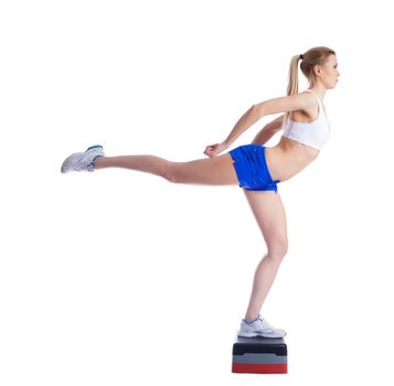 Young fitness woman on stepper. Isolated on white
