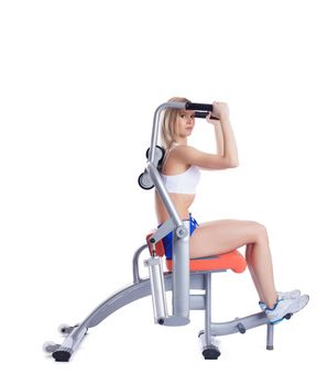Blonde young woman on isodynamic exerciser. Isolated on white