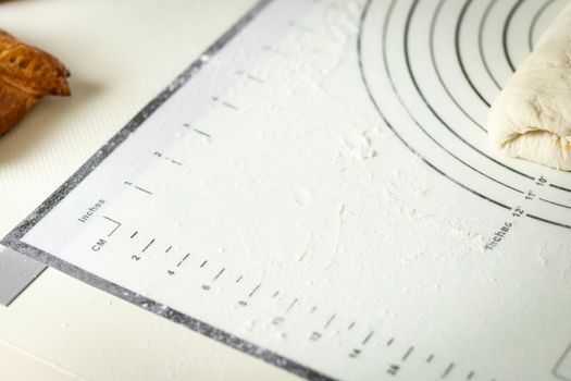 White silicone baking mat with centimeter and inch markings sprinkled with flour, copy space.