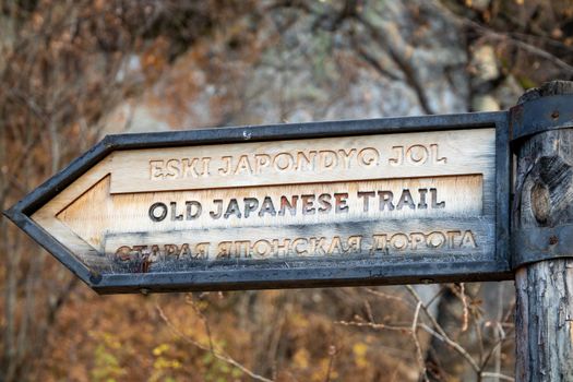 Signpost with the direction and name of the popular hiking trail The Old Japanese Trail in the Great Almaty Gorge in Kazakhstan.