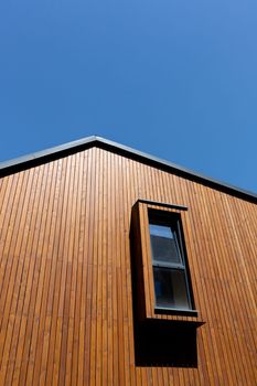 Wooden plank gabled roof on a new modern house with window, copy space.