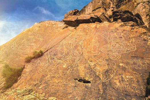 3 ancient images of Buddha on a rock in the Tamgaly tas tract on the Ili River in the Almaty region of Kazakhstan.